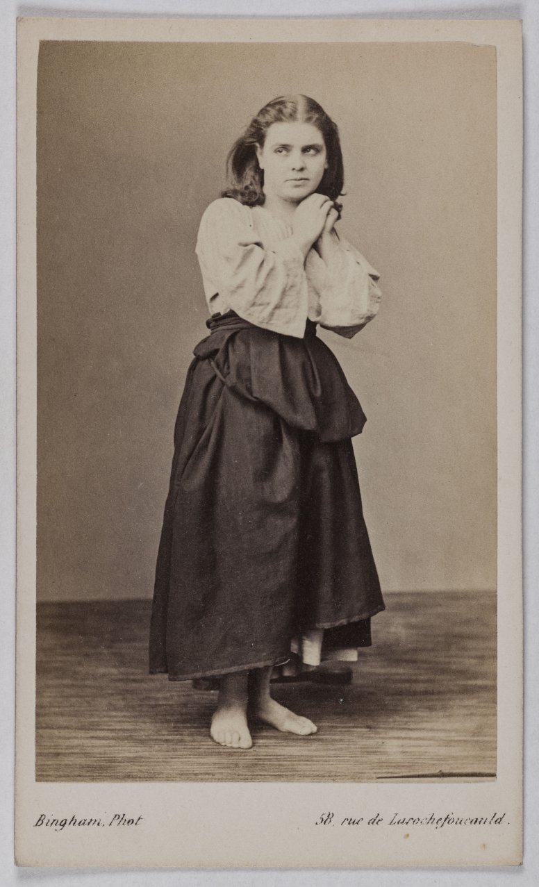 	<p>En 1866, célestine Galli-Marié crée le rôle-titre de <em>Mignon</em> d’Ambroise Thomas. Costume, coiffure et pose copient un tableau d’Ary Scheffer, Mignon regrettant sa patrie (1839), que les gravures d’Aristide Louis ont popularisé.</p>
 